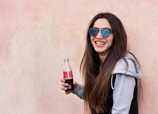 Pourquoi est-il bon de boire du coca quand on a mal au ventre ? femme avec une bouteille de coca à la main